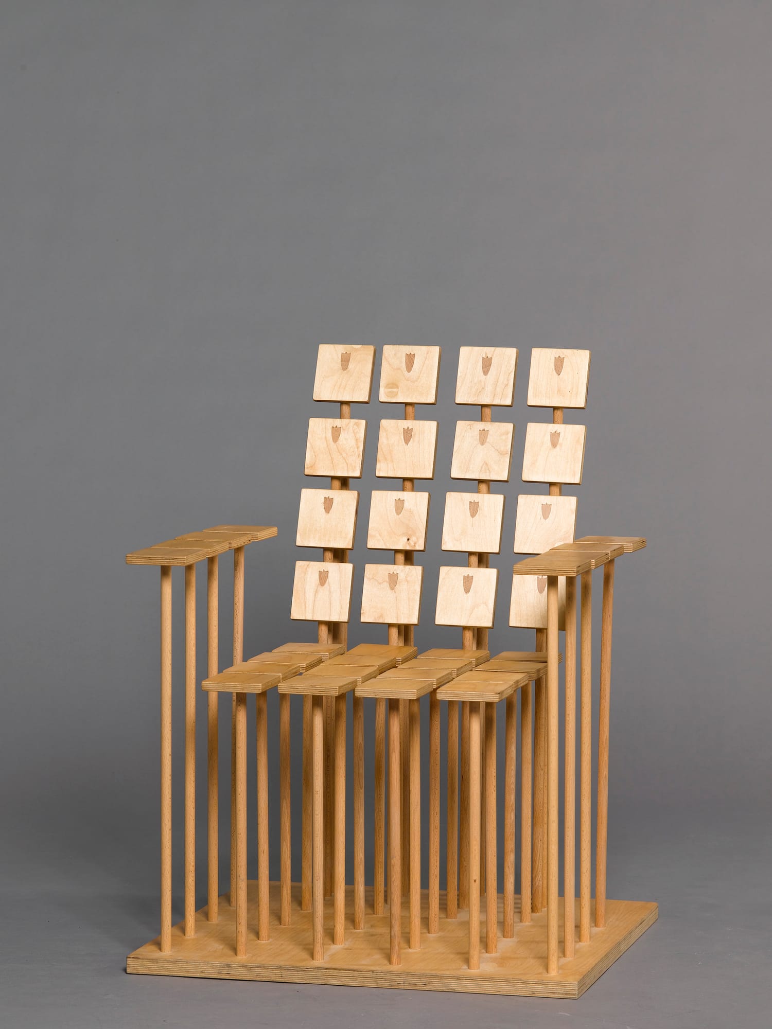 PRACHTWERK Stuhl – FANY-Stuhl aus zahlreichen Holzdübeln mit quadratischen Sitz- und Rückenplatten, Studioaufnahme auf grauem Hintergrund.